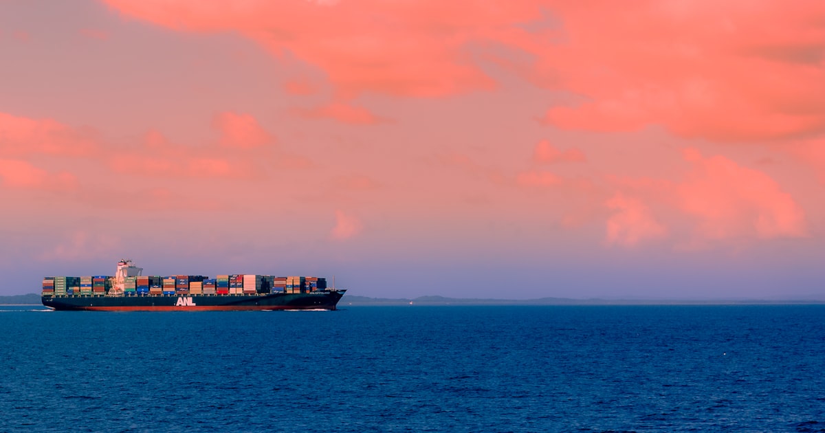 Customs agent with clipboard at a container port at golden hour with UK and Cyprus flags on containers